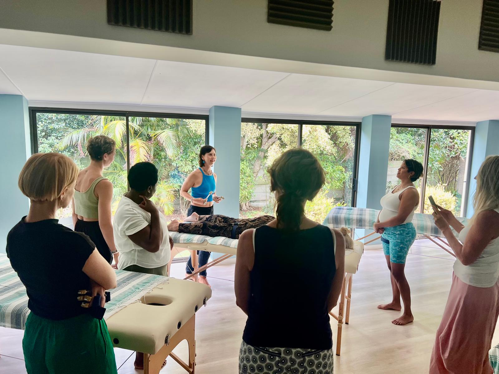 Amanda Lamprecht teaching an Acutonics training around massage tables