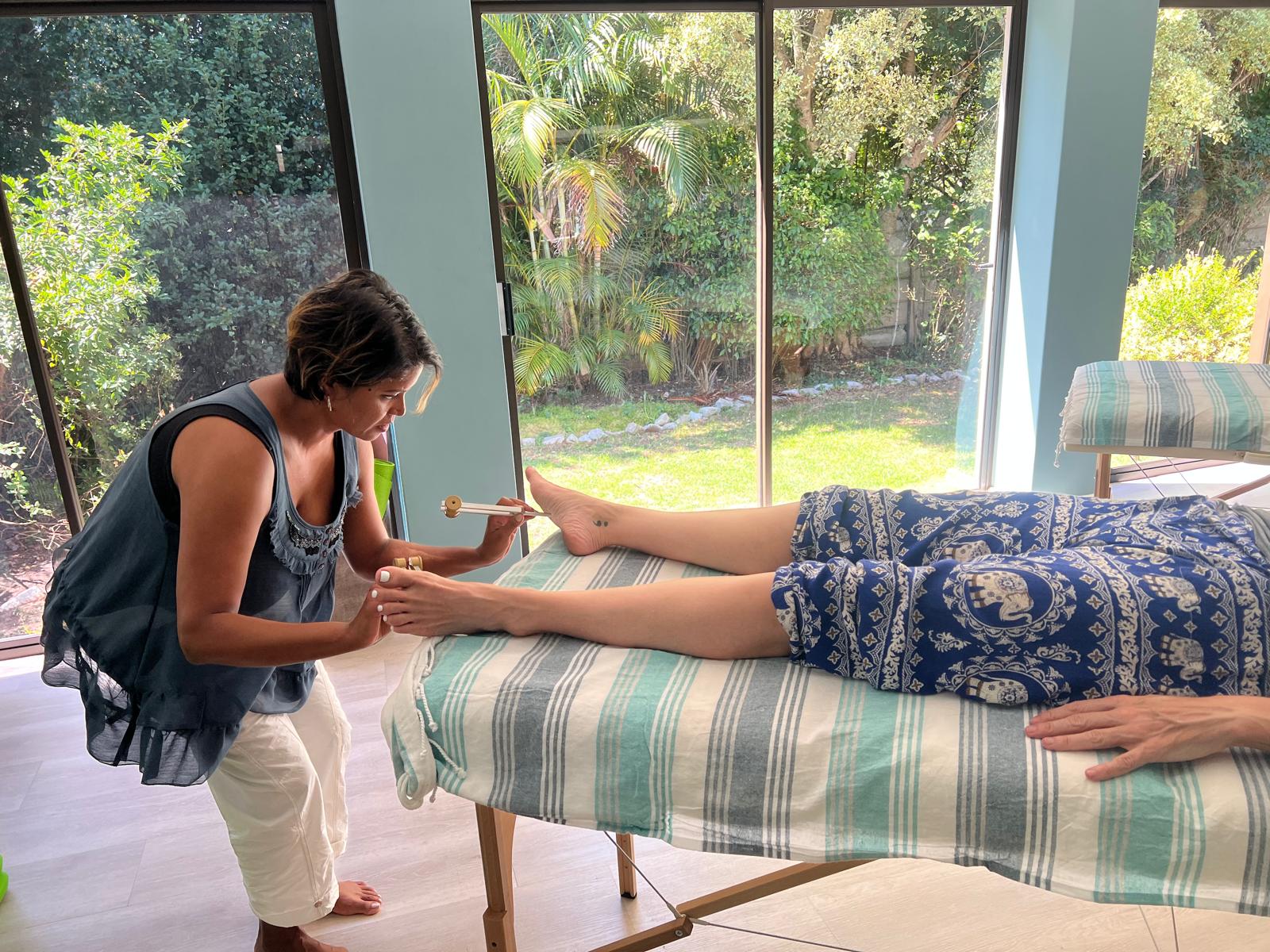 Practitioner working with forks at the client's foot