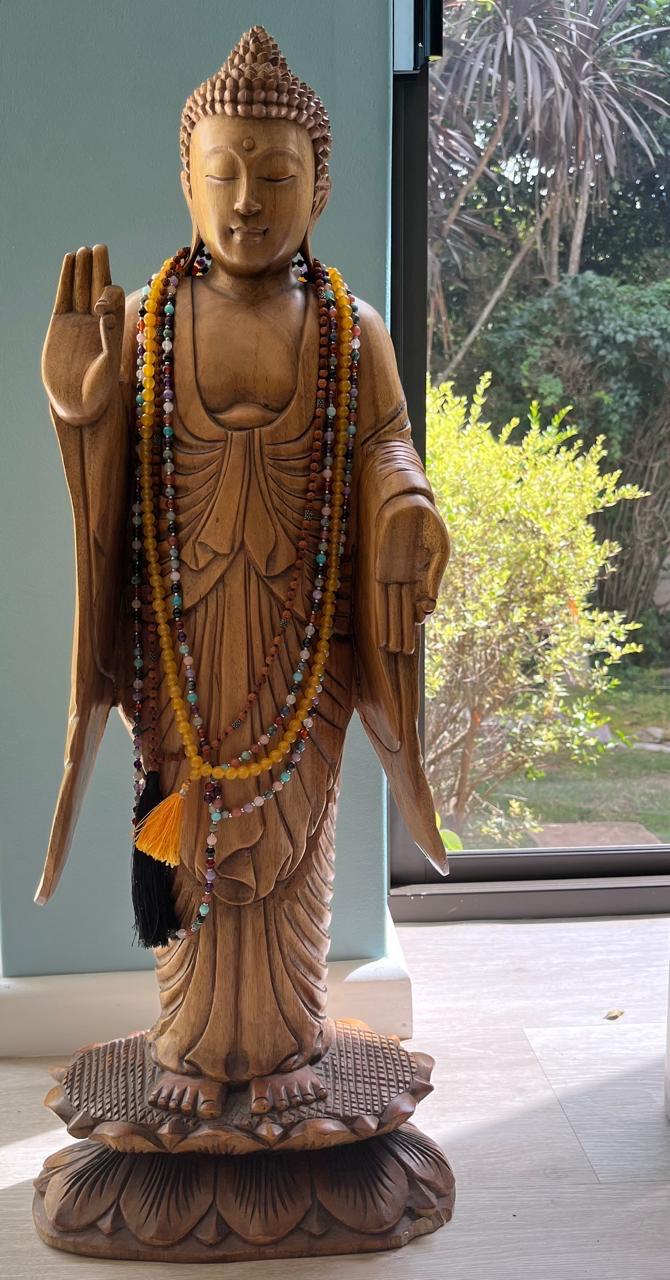 Carved wooden Buddha with mala beads in the training space